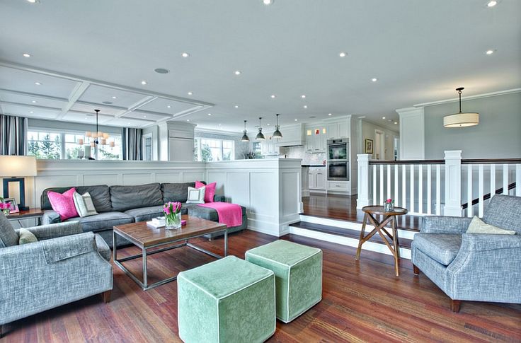 a living room filled with lots of furniture next to a wooden floor covered in white walls