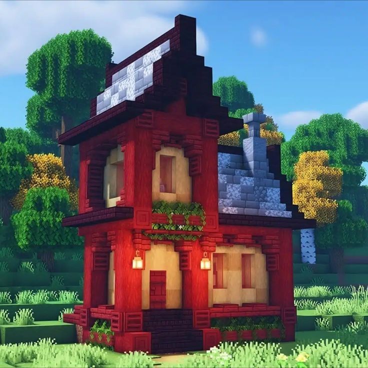 a red house in the middle of a green field with trees and bushes around it