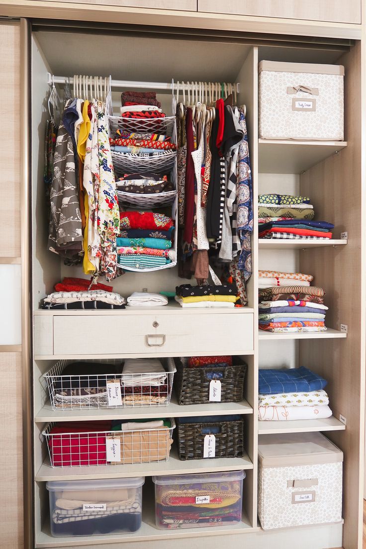 an organized closet with clothes and baskets