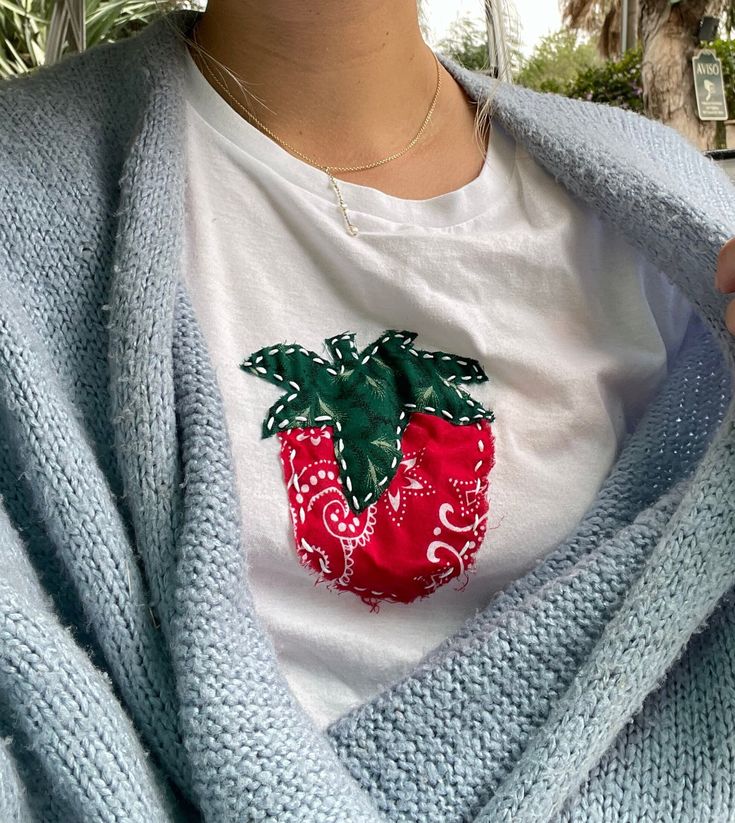 a woman wearing a white t - shirt with a strawberry on it