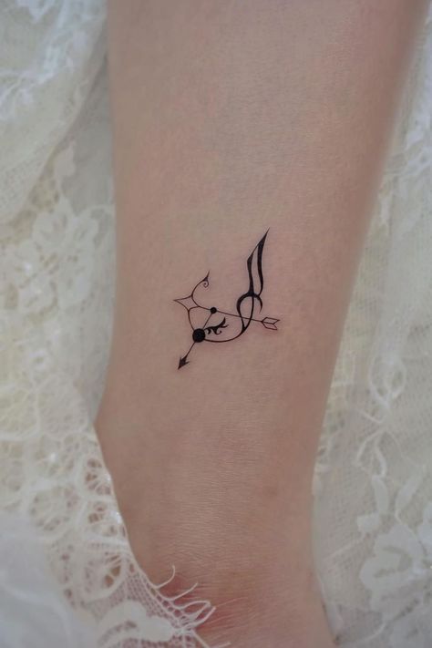 a small tattoo on the ankle of a woman's foot with a bird flying above it