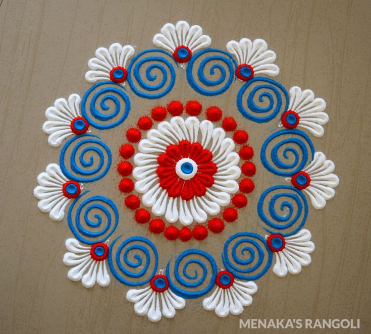 a circular design made with red, white and blue beads on top of a wooden surface