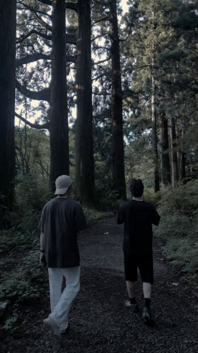 two men walking down a path in the woods