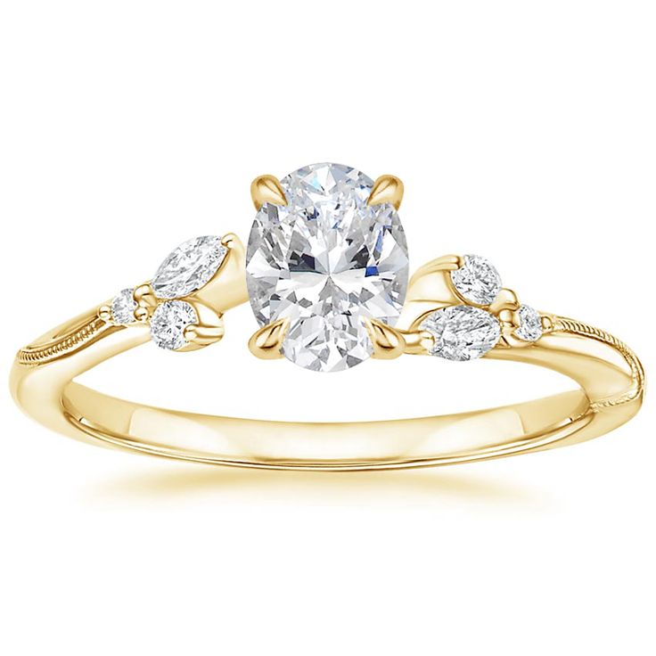 a yellow gold engagement ring with two pear shaped diamonds on the band and an oval center stone