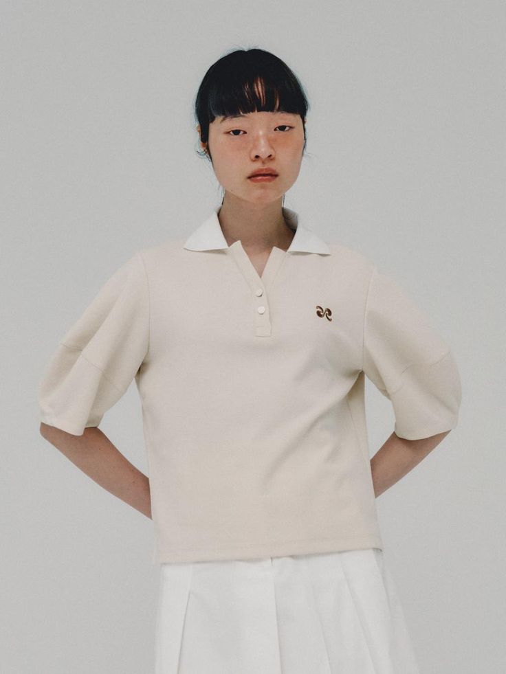 This is a modern and unique top by ahwe that is made out of high quality and sturdy fabric. With minimal design detail and trendy mood, you can style it for your casual and refined daily outfit.- Voluminous lantern sleeves detail- Two button with unique collar- Logo symbol embroidery on the chest Elegant Summer Tops With Ribbed Collar, Modern White Tops With Collared Neckline, Cream Casual Puff Sleeve Top, Casual Cream Puff Sleeve Top, Cream Puff Sleeve Casual Top, Workwear Tops With Cuffed Sleeves And Collar, Modern Collared Tops For Workwear, Beige Collared Top For Office, Chic White Top With Ribbed Collar