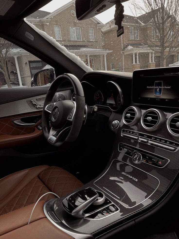 the interior of a mercedes c - class sedan with brown leather seats and steering wheel