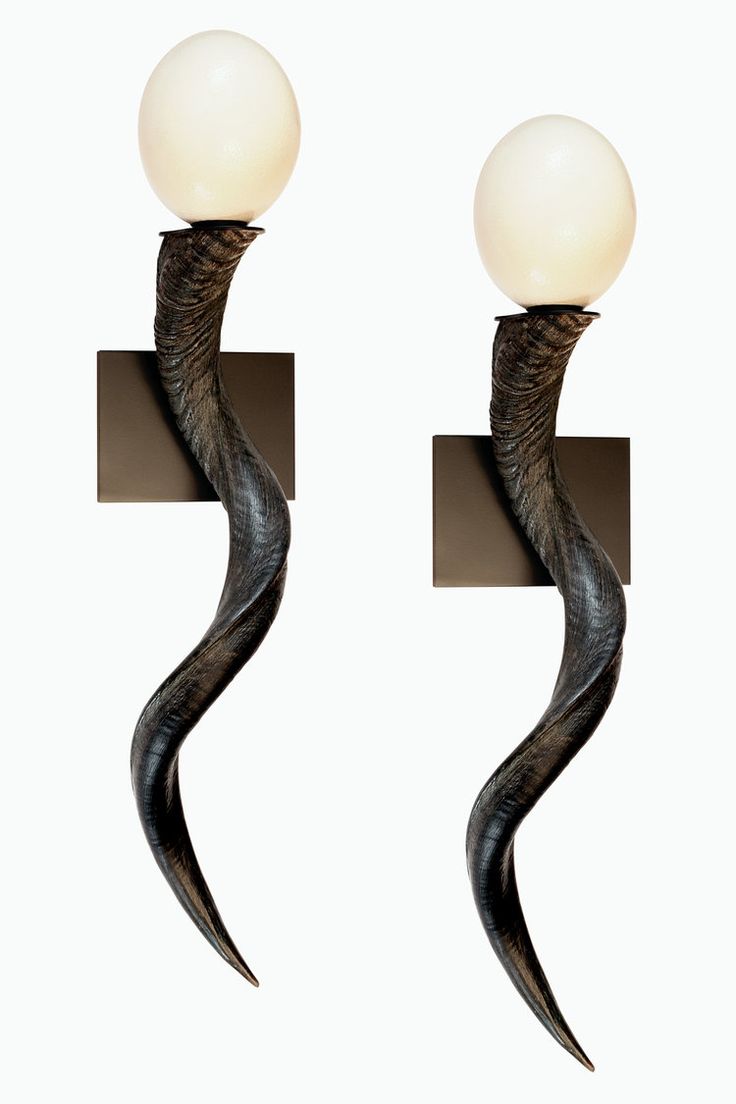 two black and white lamps with long curved stems on each side, one light is turned off