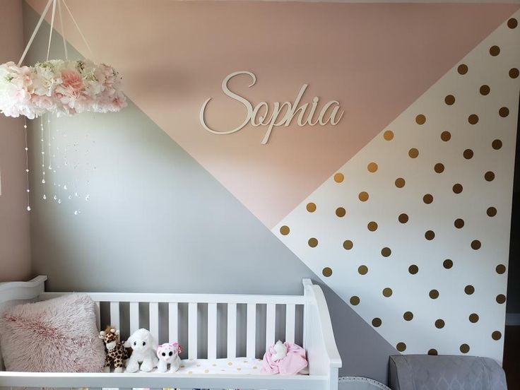 a baby's room decorated in pink, white and gold with polka dots on the wall