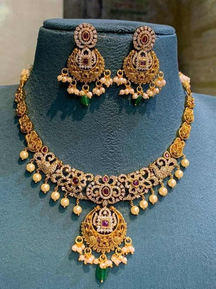 This set goes with all festive occasion dresses and it is a Statement piece . DETAILS: Includes one necklace and two earrings. Length : 14cm  Type : Close neck set or adjustment can be made with extension thread  Material: Imitation gold, kemp stones.  Finish: Premium-quality, light-antique gold finish.  PRODUCT CARE: - Avoid contact with heat/fire, water, and chemicals such as perfumes or any sprays to prevent product damage.  - Store it in the white base cover and box provided by us . Luxury Temple Jewelry Beaded Necklaces For Festivals, Luxury Temple Jewelry Necklaces For Festive Occasions, 22k Gold Necklace Indian Jewelry Kameswari Jewellers, Luxury Kundan Temple Jewelry Necklace, Luxury Traditional Temple Necklace With Gold Beads, Luxury Round Temple Necklace For Gift, Affordable Gold Kundan Necklace For Festive Occasions, Luxury Temple Necklace With Stone Setting For Festive Occasions, Luxury Temple Jewelry Danglers For Formal Occasions