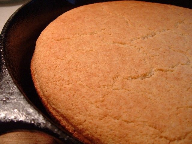 a close up of a cake in a pan on a stove top with a spatula