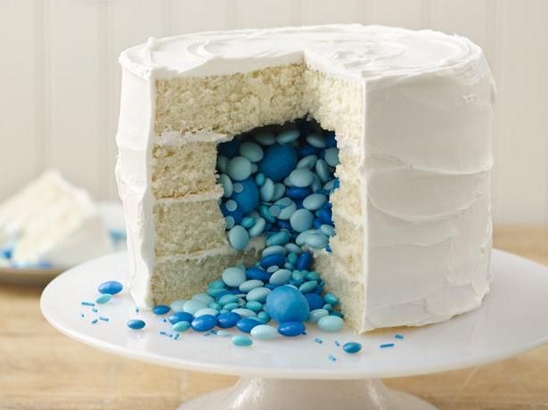 an image of a cake with blue and white frosting on the top, next to a book