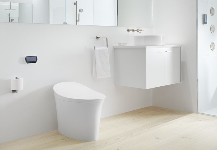 a modern bathroom with white fixtures and wood flooring