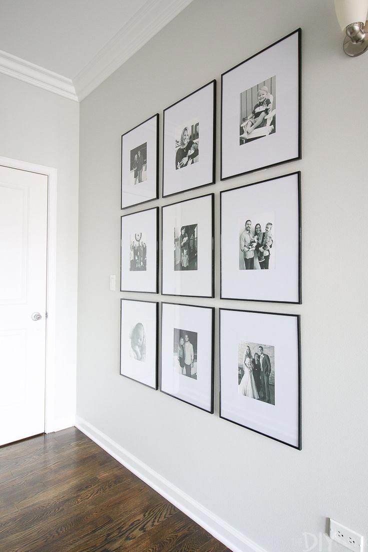 a white wall with black and white pictures hanging on it's side, along with a wooden floor