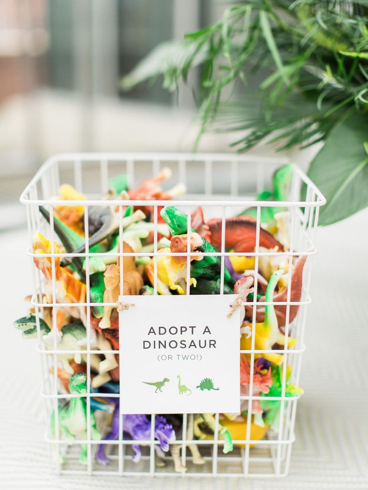 a white basket filled with lots of different types of food next to a potted plant