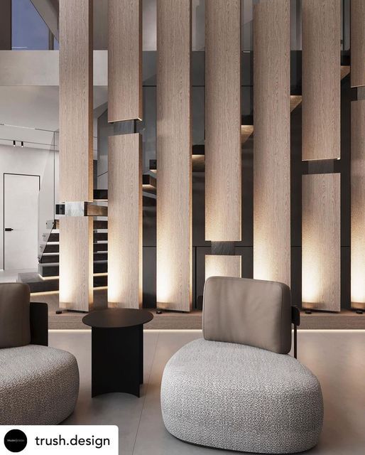 a living room filled with furniture next to a stair case covered in wooden slats