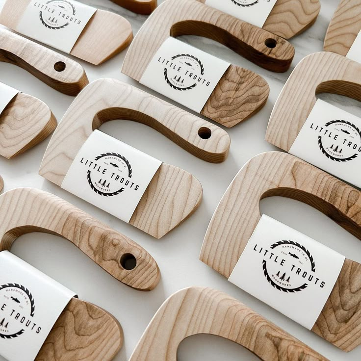 wooden cutting boards with labels on them sitting on top of a white tableclothed surface