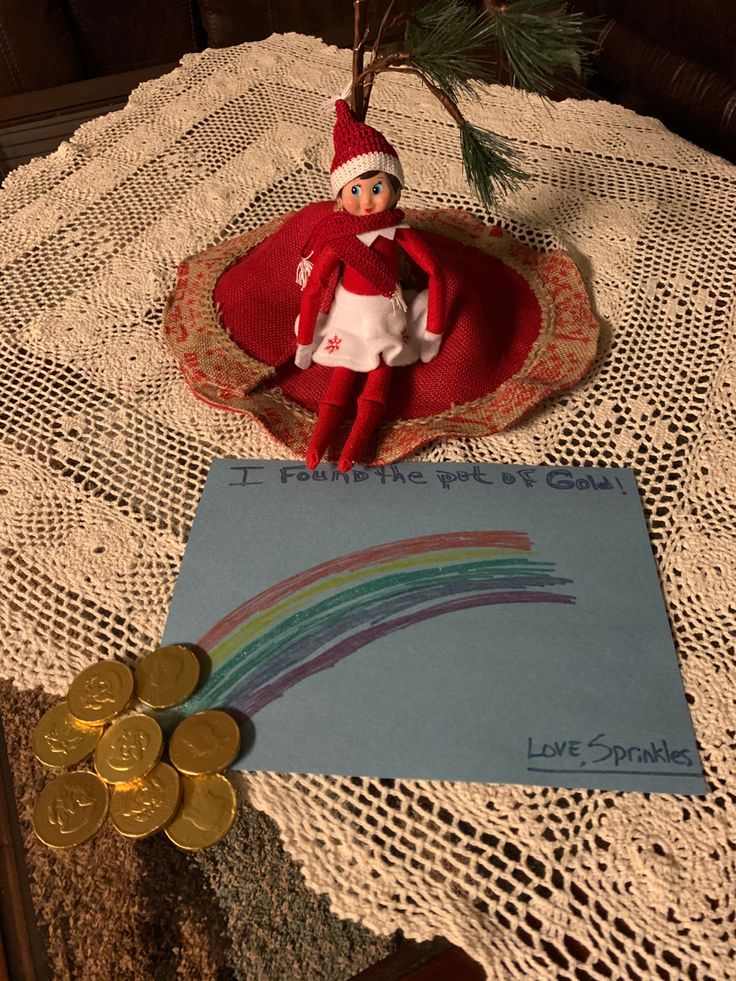 an elf is sitting on top of a table next to some coins and a note