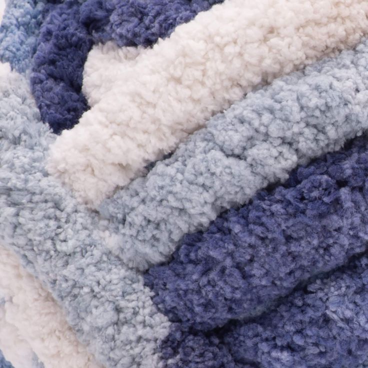 a pile of blue, white and grey blankets