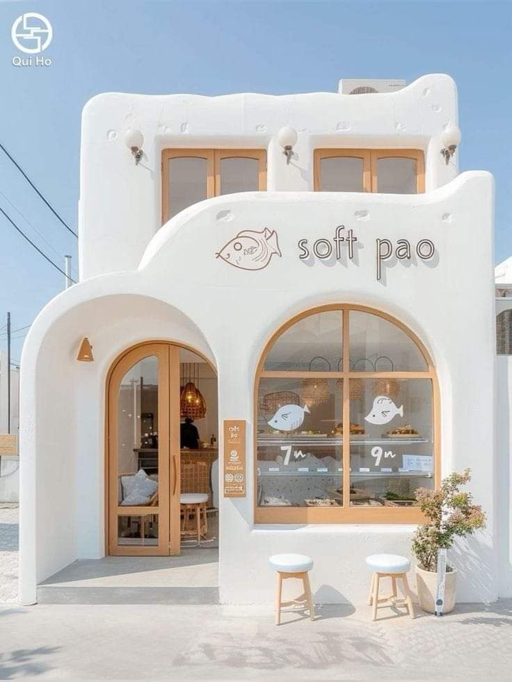 a white building with some windows and two stools in front of the window that says soft pao