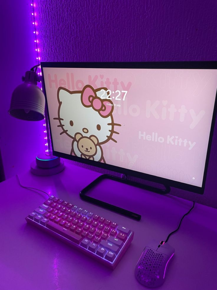 a desktop computer with a hello kitty wallpaper on the screen and keyboard next to it