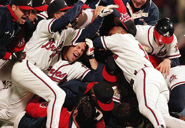 a group of baseball players are piled on top of each other