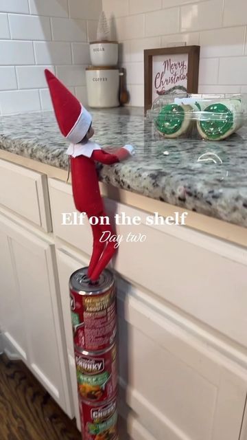 an elf is standing on top of a can in the middle of a kitchen counter