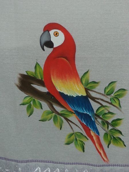 a red parrot sitting on top of a tree branch with green leaves around its neck