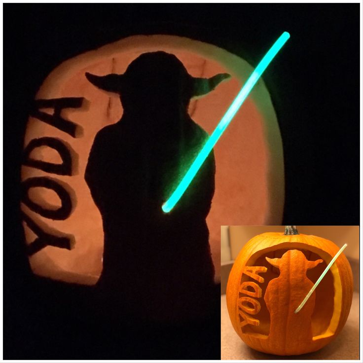 a carved pumpkin with a star wars yoda light saber on it's side