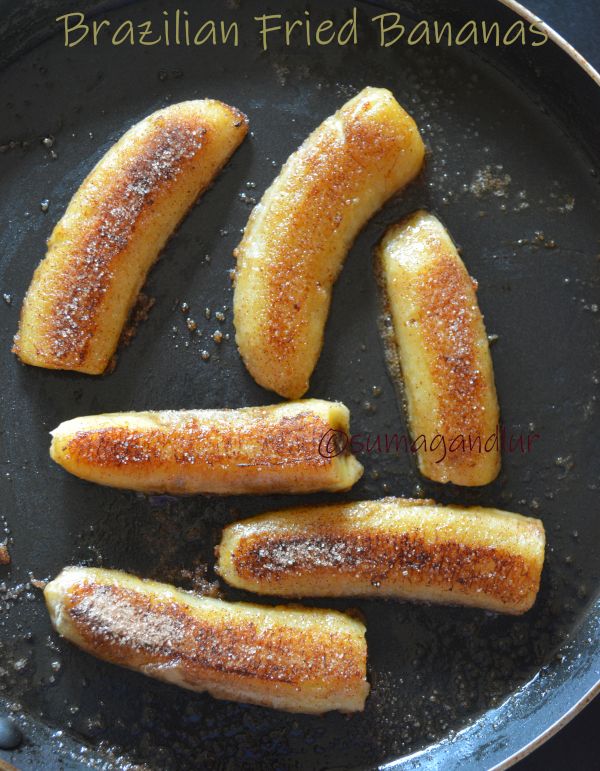 fried bananas in a frying pan with sugar on top