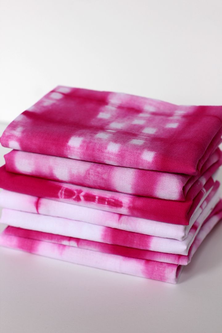 pink and white tie - dyed fabric stacked on top of each other in front of a white background