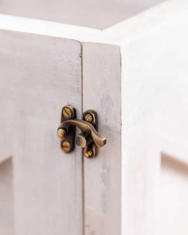 a white cabinet with brass handles and knobs