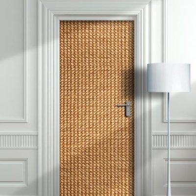 the door is made out of straw and has a lamp on it next to it