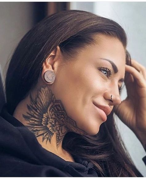 a woman with tattoos on her neck and behind her ear is looking at the camera