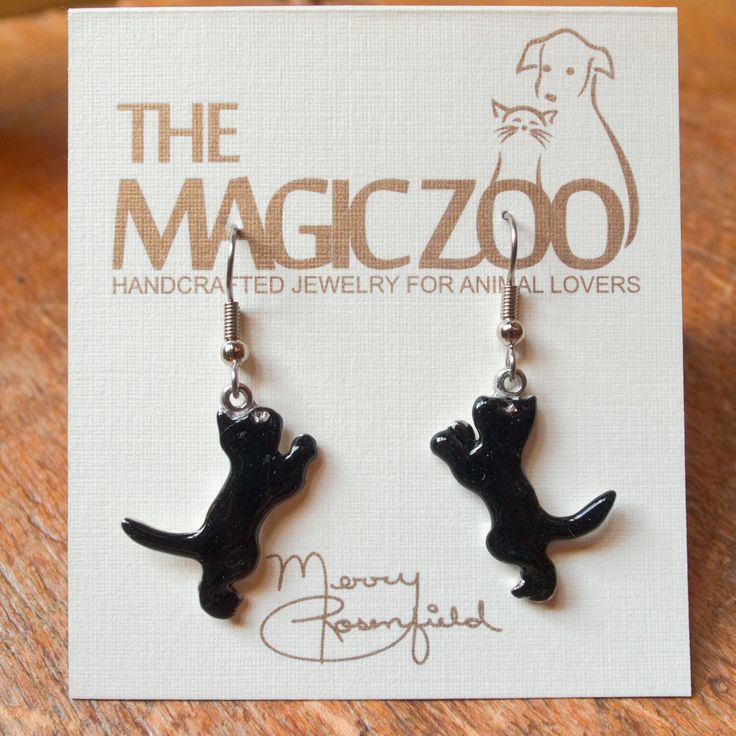 "These enamel black cat earrings make a fantastic gift for the cat lover! Do you happen to think black cats bring good luck! I do, and why not? These handcrafted and hand painted earrings are each 1\" tall by 3/8\" wide and come on stainless steel ear wires. By the way, they would be wonderful to wear on Halloween! When I create a pair of enamel earrings, they are usually created mirror-image style, with the right and left earring facing each other. Because of the hand crafted nature of my work, Black Novelty Jewelry For Gifts, Black Cat Ears Jewelry With Cat Design, Novelty Black Cat Design Jewelry, Black Cat Design Novelty Jewelry, Novelty Black Jewelry With Cat Design, Black Novelty Jewelry With Cat Design, Handmade Black Enamel Earrings, Black Cat Ears Jewelry For Gifts, Black Cat Ears Jewelry As A Gift