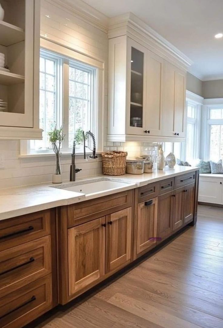 a large kitchen with wooden cabinets and white counter tops, along with hardwood flooring