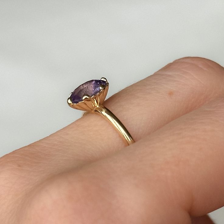 Combining timeless elegance with a touch of sea-inspired charm, our Scallop Cup Solitaire is a one-of-a-kind ring! It features a weighty, 14k recycled yellow gold band with a classic, rounded shank and polished finish. This specific Scallop Cup Solitaire features a beautiful, pastel purple oval sapphire from Sri Lanka. Center Stone Details: Gemstone: Sapphire Hardness: 9/10, great for everyday wear! Carat Weight: 1.97ct Shape + Cut: Modern Oval Brilliant/Roval Origin: Sri Lanka Dimensions: 8.47x Timeless Yellow Gold Amethyst Ring With Oval Shape, Timeless Oval Amethyst Ring For Gift, Timeless Oval Amethyst Ring As Gift, Oval Solitaire Amethyst Ring In 14k Gold, Oval Solitaire Amethyst Ring In Yellow Gold, Yellow Gold Oval Amethyst Ring With Prong Setting, Oval Amethyst Ring In Yellow Gold With Prong Setting, Fine Jewelry Oval Amethyst Ring In 14k Gold, Classic Lavender Oval Jewelry