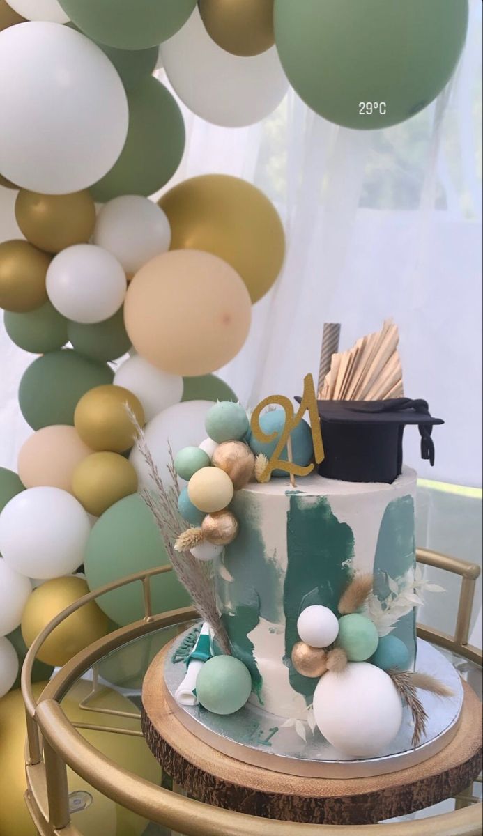 there is a cake on the table with balloons in the background and decorations around it