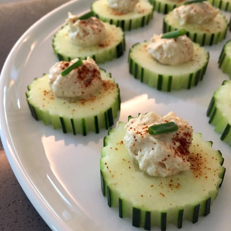 cucumber slices topped with cream and garnish on a white platter