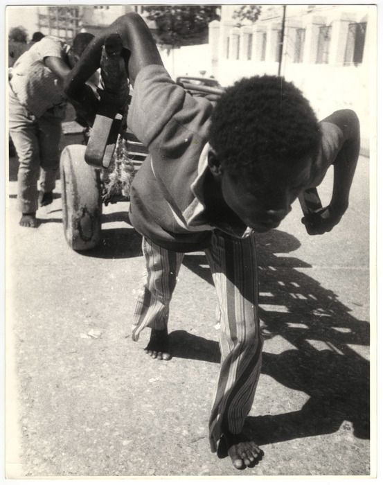 a young man is doing a handstand on the ground in front of other people