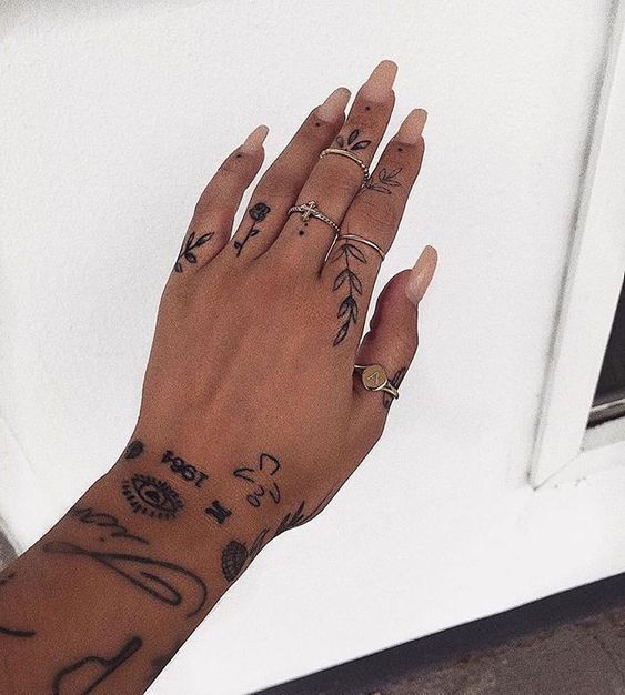 a woman's hand with tattoos on her left wrist and fingers, next to a door