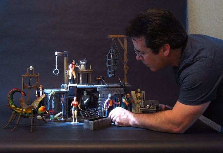 a man sitting at a table with toys on it