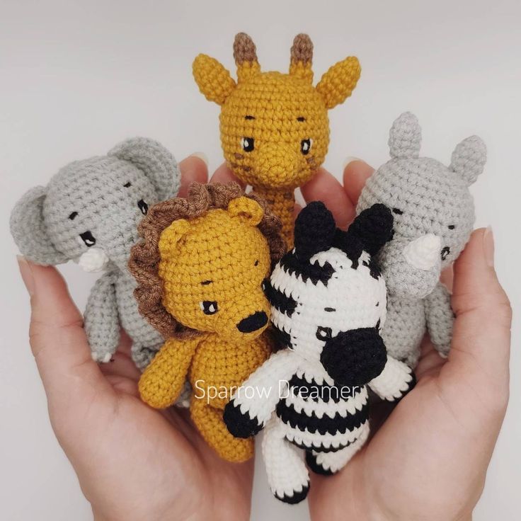 small crocheted stuffed animals are in the palm of someone's hand,