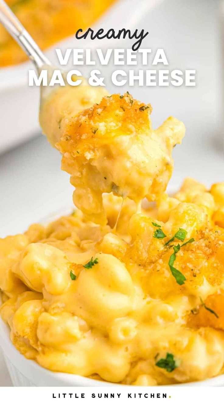 a spoon full of macaroni and cheese is being lifted from a white bowl