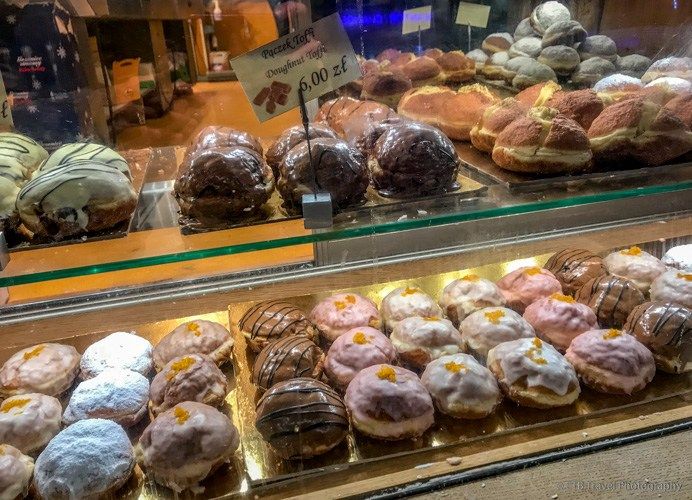 a display case filled with lots of different types of doughnuts and pastries