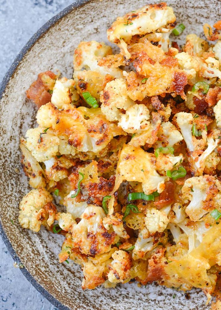 a bowl filled with cooked cauliflower on top of a table