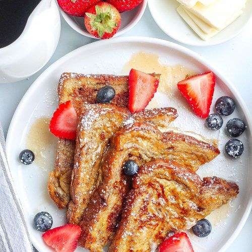 french toast with strawberries and blueberries on a plate