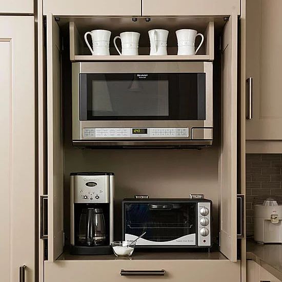 a microwave oven sitting on top of a wooden cabinet next to a toaster and coffee maker