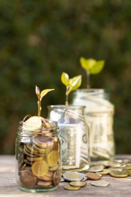 three jars filled with coins sitting on top of a wooden table next to each other