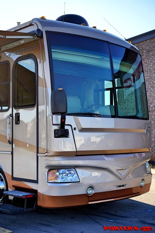 an rv parked in front of a brick building with the sun shining on it's windows