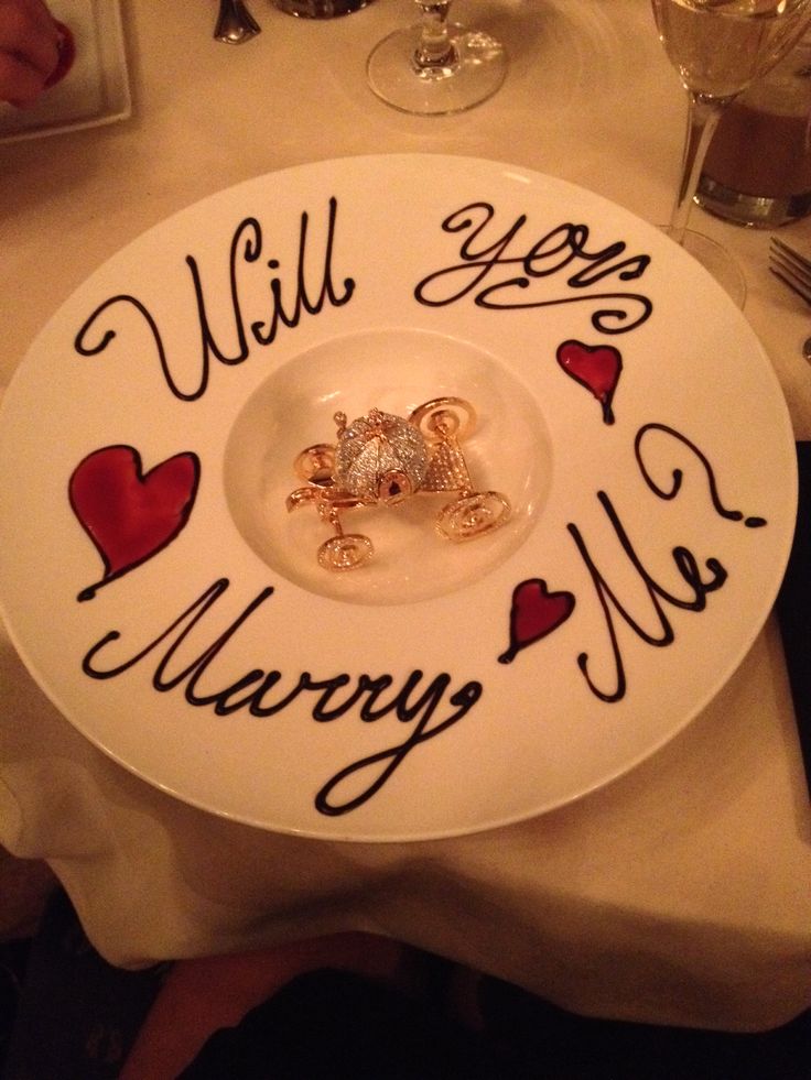 a white plate topped with two wedding rings on top of it and the words will you marry me?